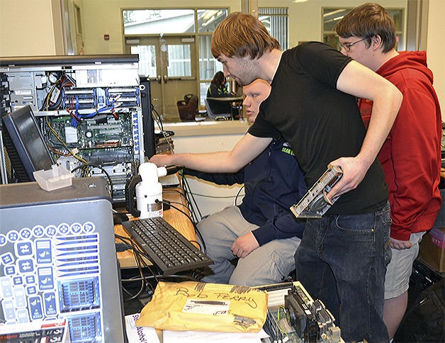 Arts and Tech High School's Blake Horenstein helps out fellow senior Xavier Melton in the computer repair lab.