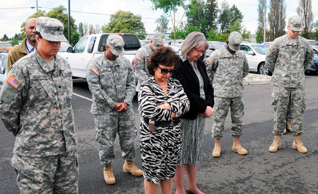 Soldiers and civilian staffers of the 364th Expeditionary Sustainment Command observe a moment of silence during the dedication of the unit’s new Gold Star Families parking space on June 13.