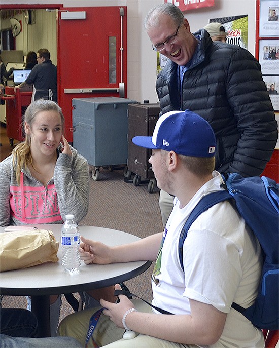 Assistant Superintendent Ray Houser laughs with students in one of the eating areas at Marysville-Pilchuck High School.