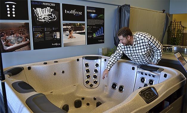 Joey Koncoski shows the panels that can be changed to give hot tub users different experiences.