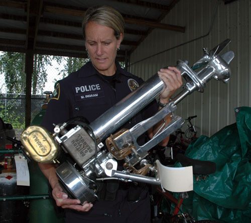 Officer Molly Ingram of the Marysville Police Strike Team inspects an antique boat motor that’s among the pieces of stolen property that the anti-burglary team has recovered since its formation nearly two months ago.