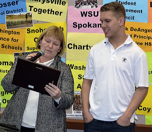Marysville-Pilchuck co-principal Deann Anguiano reads a plaque she is about to give to Student of the Month Drew Hatch.