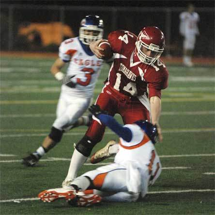 Quarterback Zack Hanson runs over a would-be Graham-Kapowsin tackler.