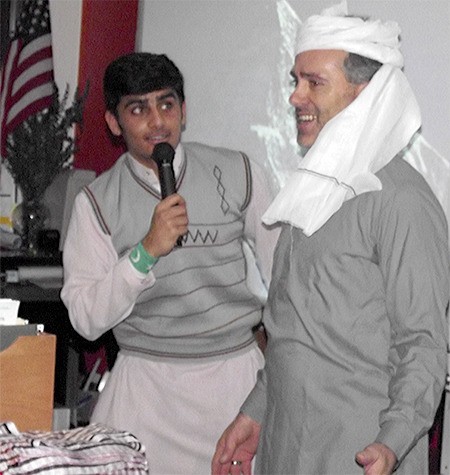 Rashid puts a turban on teacher Johnny Booker.