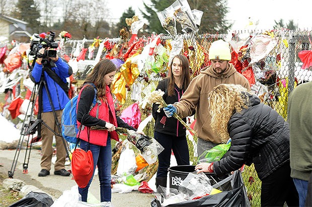 Students and community members remove memorials left behind on Marysville-Pilchuck's fence one month after the school shooting.