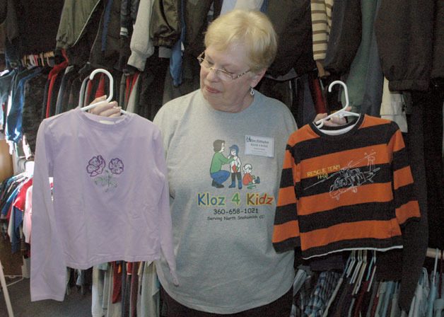 Kloz 4 Kidz Director Lynn Brittingham sizes up some donated shirts before hanging them on their racks for area children in need.