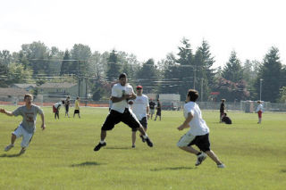 Junior K.B. Kennebrew catches a toss in the middle of coverage during a passing drill in a Tomahawk football camp.