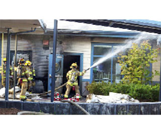 Local firefighters work to extinguish an exterior fire at Lakewood Elementary School.