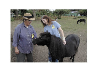 Equine Rescue Association director Vell Moore and association board vice president Suzette Acey spend some time greeting Blackie