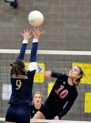 Marysville-Pilchuck senior Lindsey Hartelroad fires a shot as Arlington setter Megan Abdo leaps to block it.