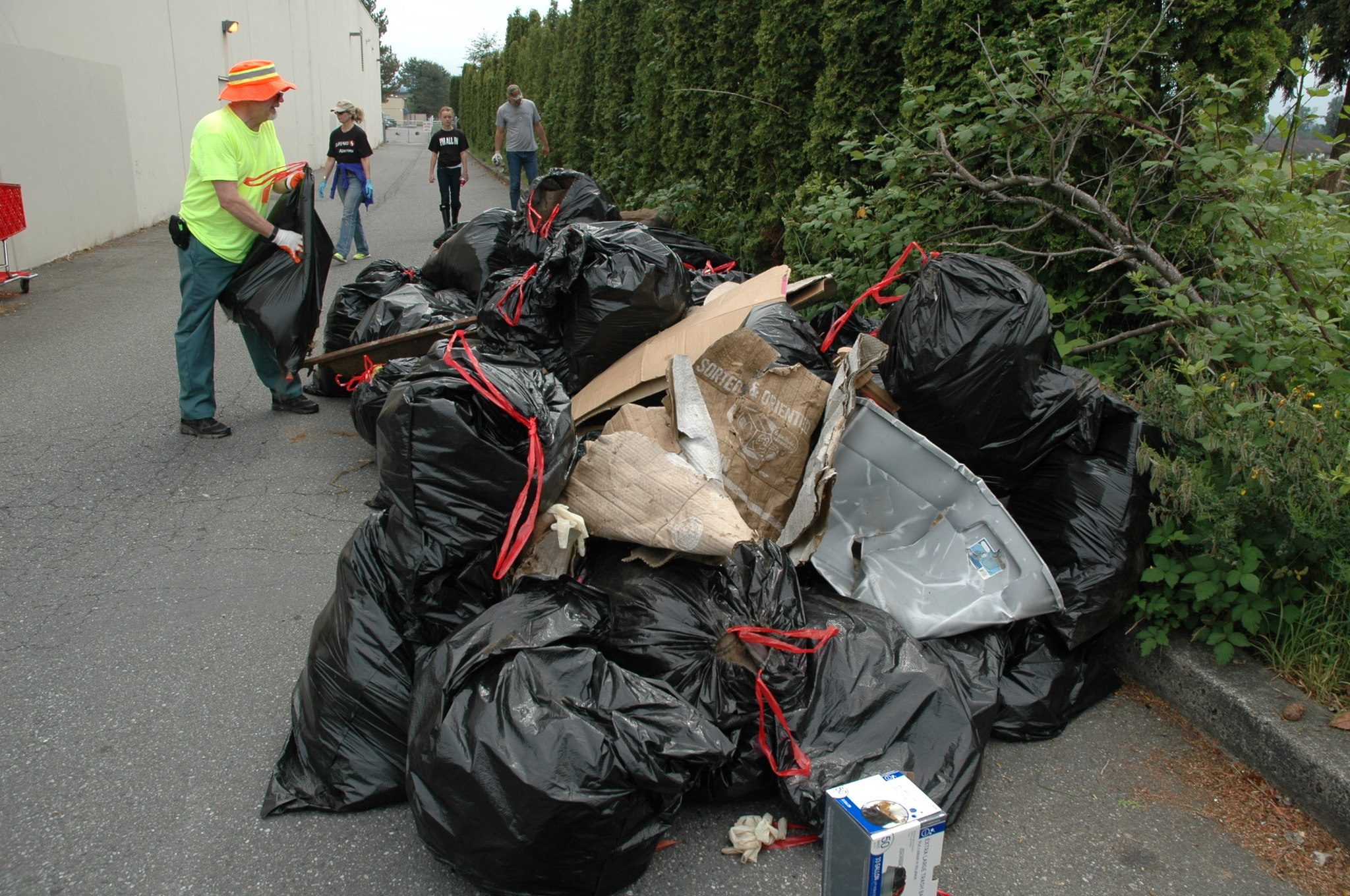 Michael Lloyd throws another trash bag on the pile during the May 14 cleanup at the Smokey Point Safeway.