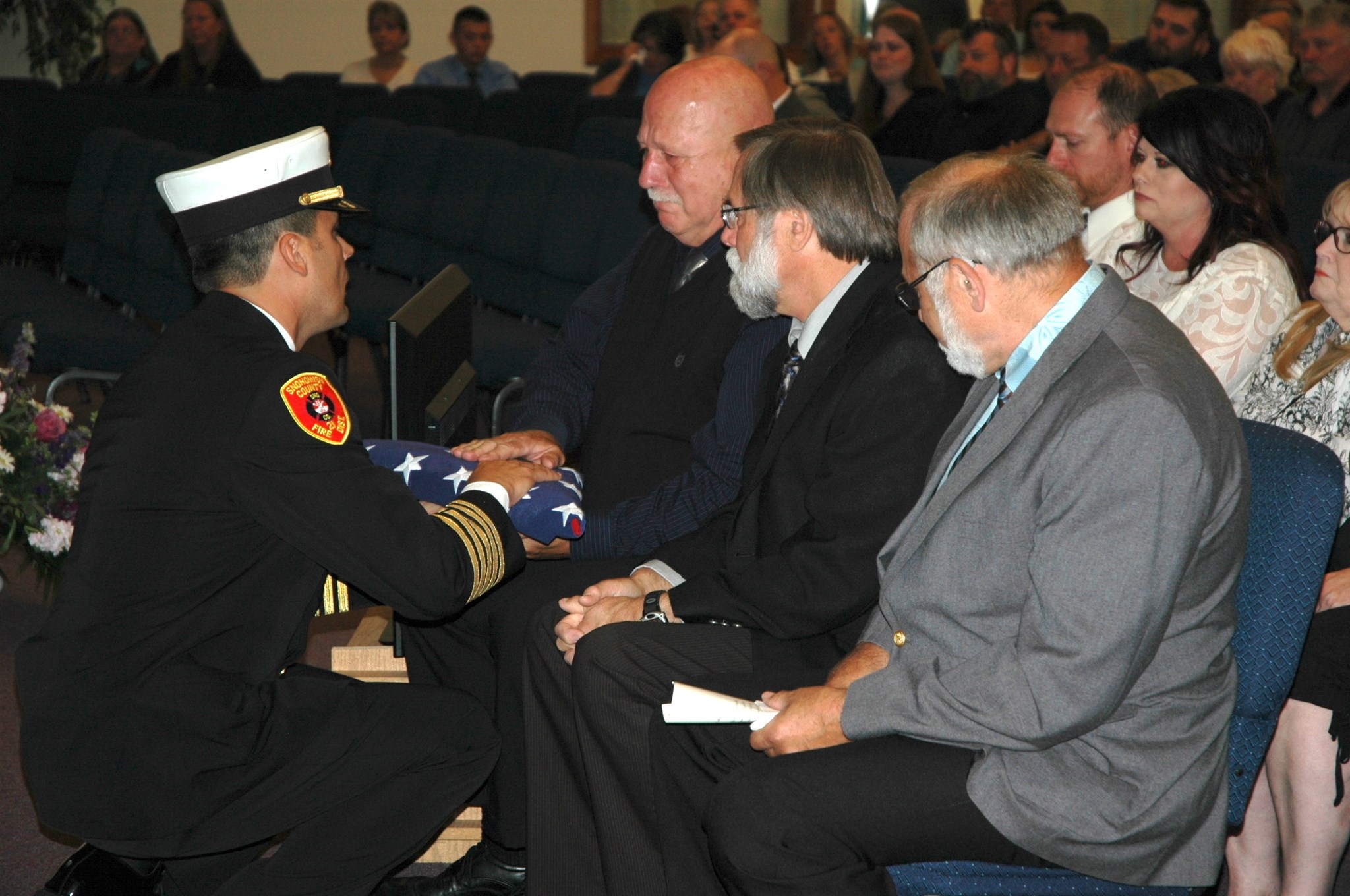 Kirk Boxleitner/Staff PhotoGetchell Fire Chief Travis Hots presents a flag to Walt Bailey’s son