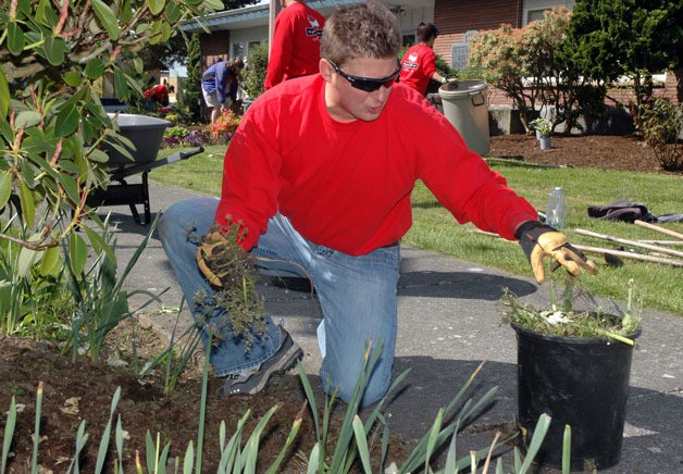 Toby Barnett of the Marysville branch of Keller Williams does weeding in the landscaped garden areas of Comeford Park as part of the May 10 ‘RED Day.’