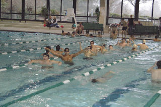 Tomahawk swimmers wave their arms as they wade through the Forest Park Pool before competing there against Everett.