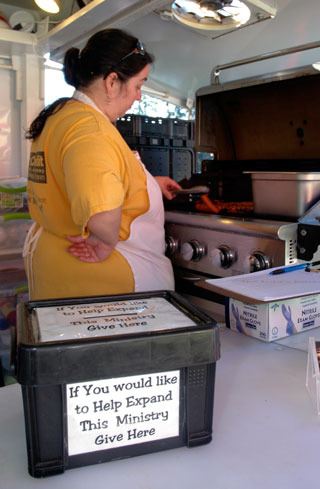 Darla Davis cooks up hot dogs for the Lord’s Kitchen during its weekly meal at Marysville Oct. 13. The Lord’s Kitchen depends heavily on volunteers and donations to provide the free meals.