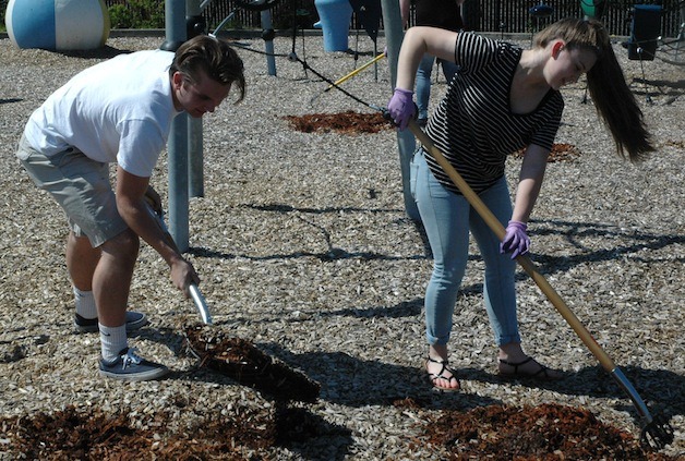 Marysville-Pilchuck High School students Jason Maki and Rachel Heichel stir up the beauty bark at the playground at the Ebey Waterfront Park in Marysville April 17.