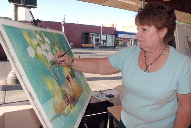 Guest artist Colleen Allen puts the final touches on a watercolor painting at Hilton Pharmacy during the ‘Art Walk’ on July 11.