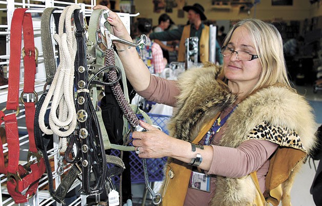 Seattle Goodwill Visual Merchandise Assistant Lisa Bayse puts the final touches on a display Aug. 12 for the Marysville Goodwill’s ‘Western Days’ sale.