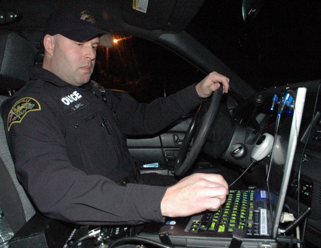 Marysville Police Detective Craig Bartl checks his license plate registration information computer in his patrol vehicle before heading out on the Dec. 14 ‘Night of 1