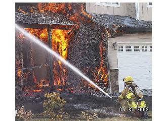 An unidentified firefighter helps take on the blaze that engulfed a home in the 3800 block of 64th Avenue.