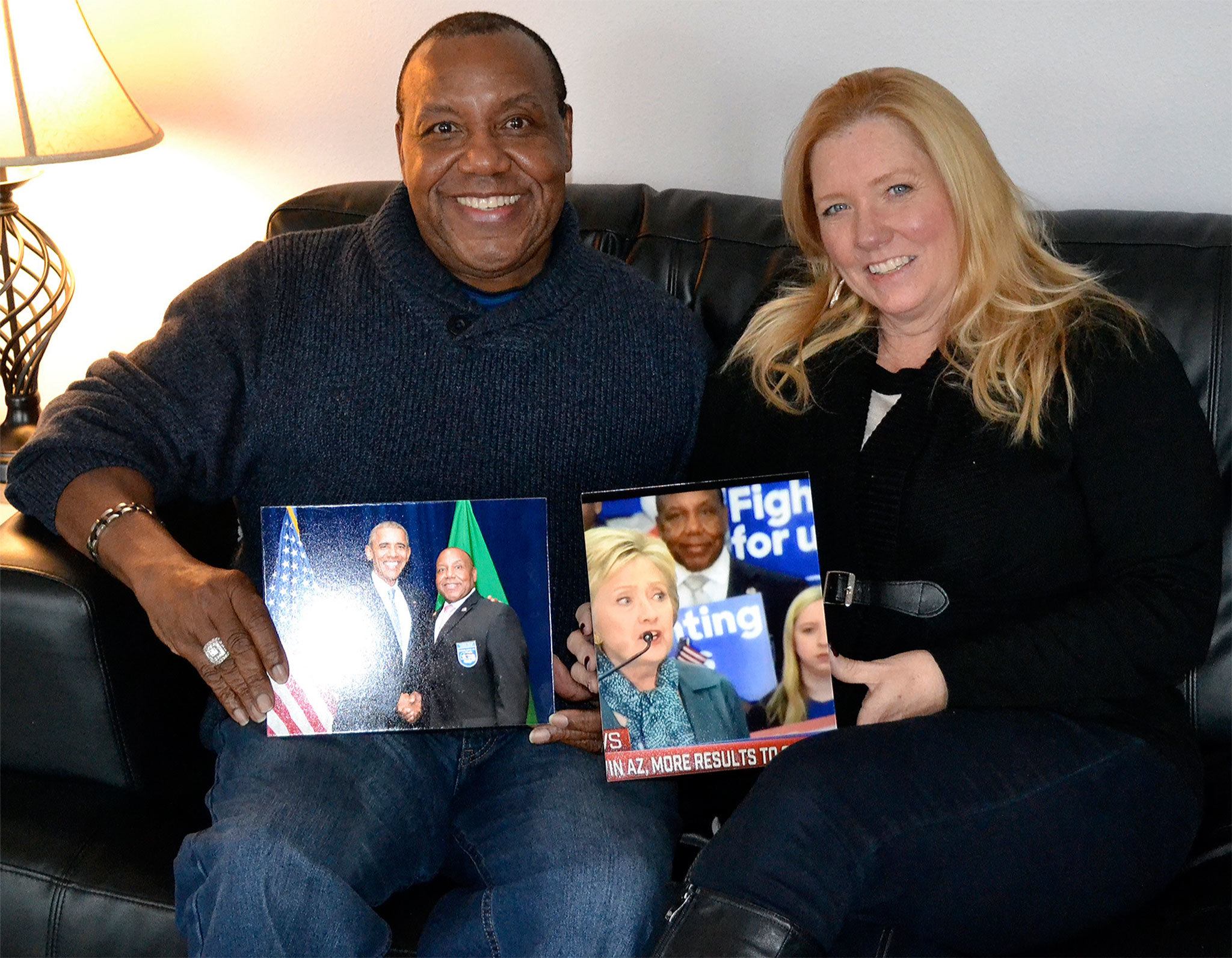 Longtime Marysville Democrat Raymond Miller holds a photo he took with President Obama, while his wife, Jennifer, holds one of her husband and presidential candidate Hillary Clinton. (Steve Powell/Staff Photo)
