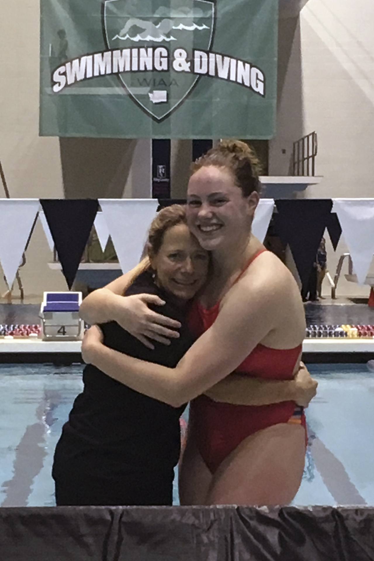 Brandon Adam/Staff Photo                                Abby Magee, right, and her swim coach Jaclin Legore Hodgins hug it out at the 3A state swim meet.