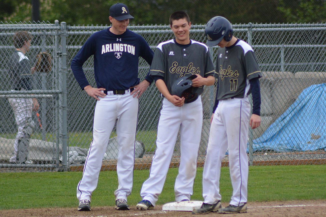 Coach Scott Striegel talks with seniors Jake Russell and Avery Kindred during a break in the action in a game earlier this year. Arlington placed third at districts with a romp over Snohomish. (Steve Powell/File Photo)