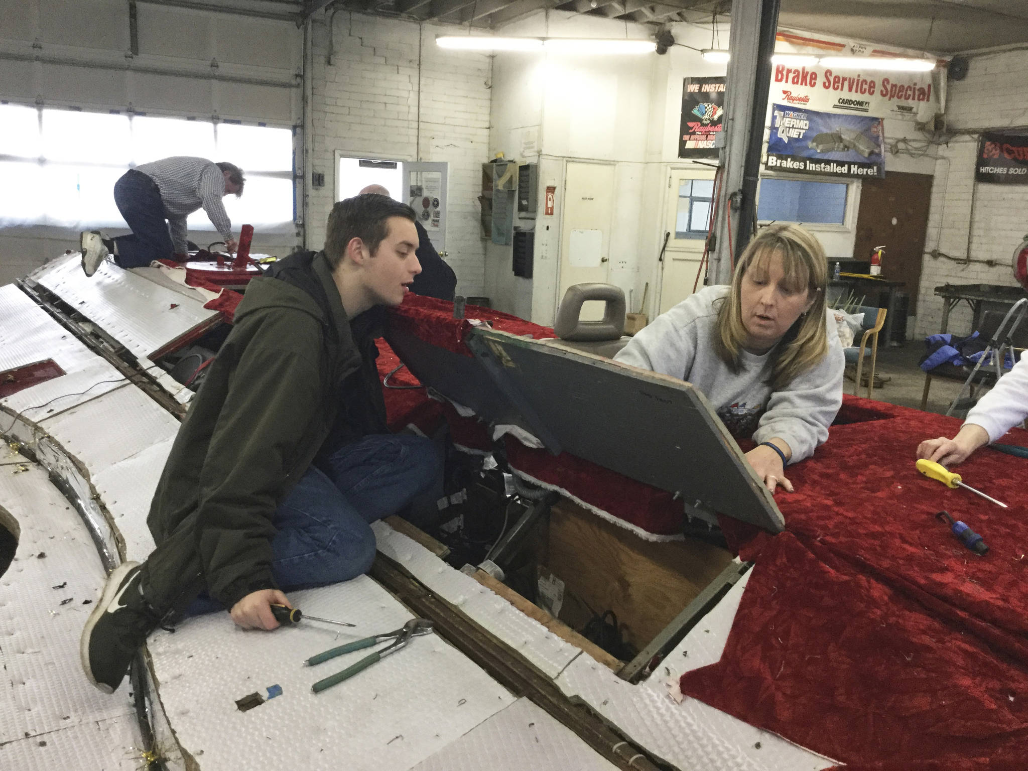 Maryfest board member Jodi Condyles and son, Peter, pull carpet up from the floor of the Marysville Strawberry Festival parade float and remove door hinges to strip down the float for this years new design and decorating.