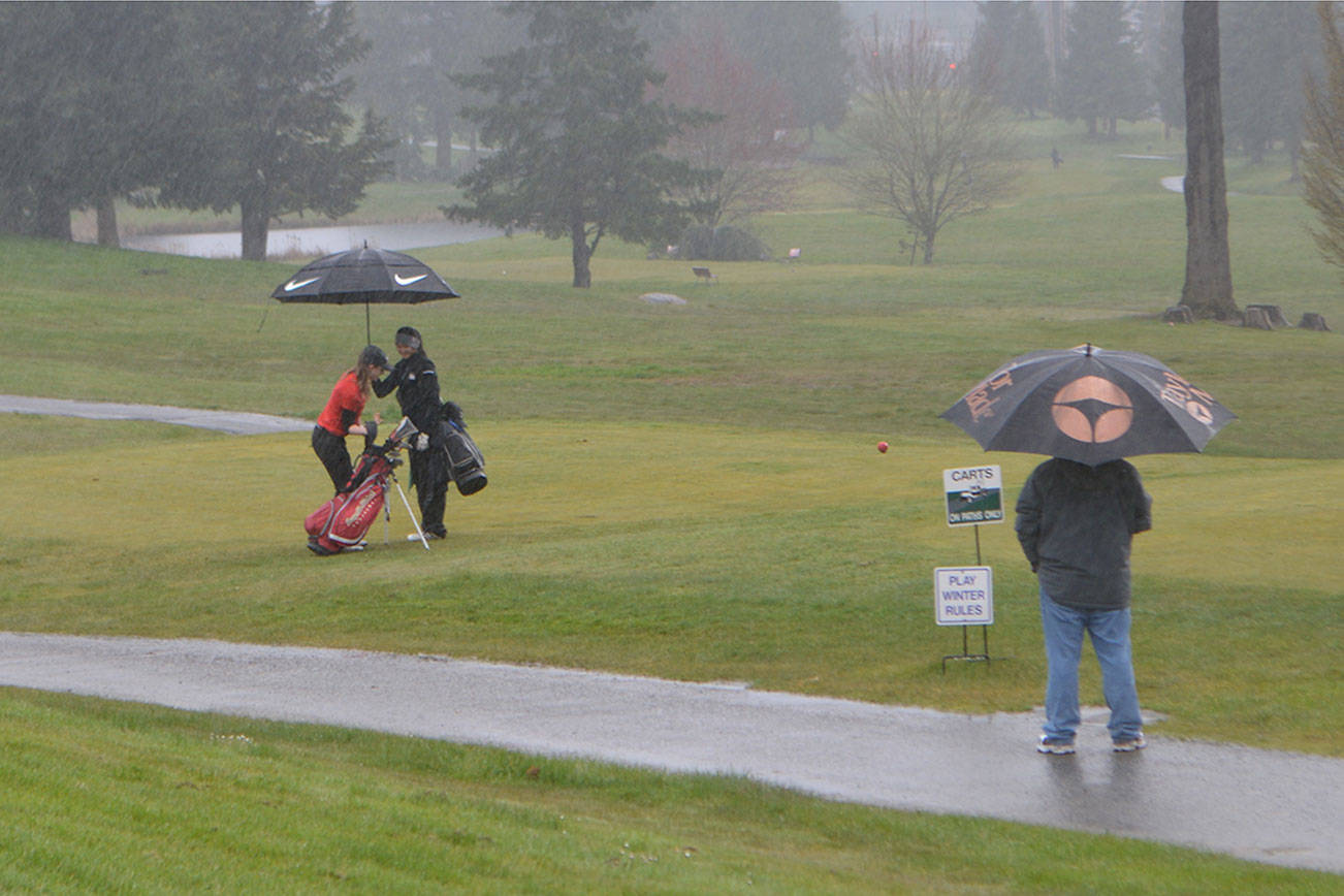 Umbrellas are used on the Marysville course almost as often as clubs. (Steve Powell/Staff Photo)