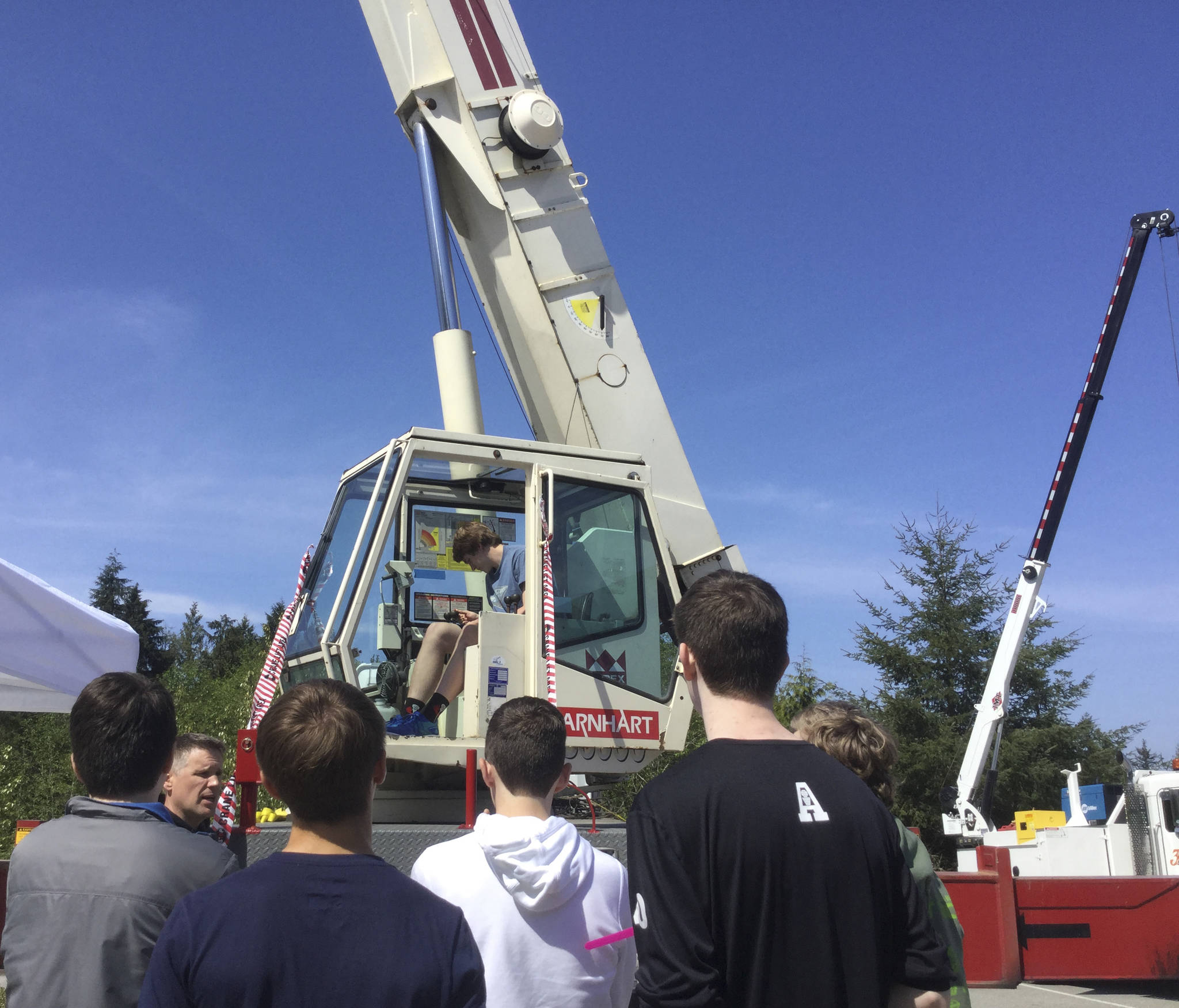 Arlington High School Junior Jonathan Schroeder takes his turn in the crane cab while Barnhart Crane & Rigging worker Ben Walthers talks about the industry with students.