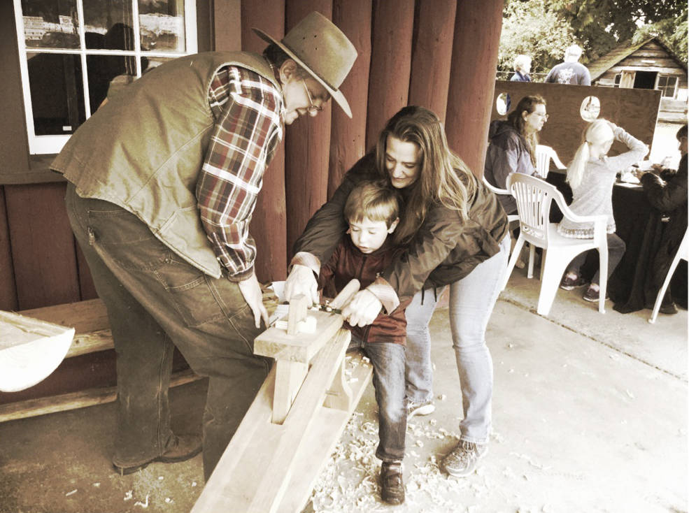 Brad Merritt, of Arlington, gets tips from renowned Arlington woodwright and farmer Bill Pierce from Soaring Swallow Woodworks, with a little extra help from the boys grandmother, Christie.