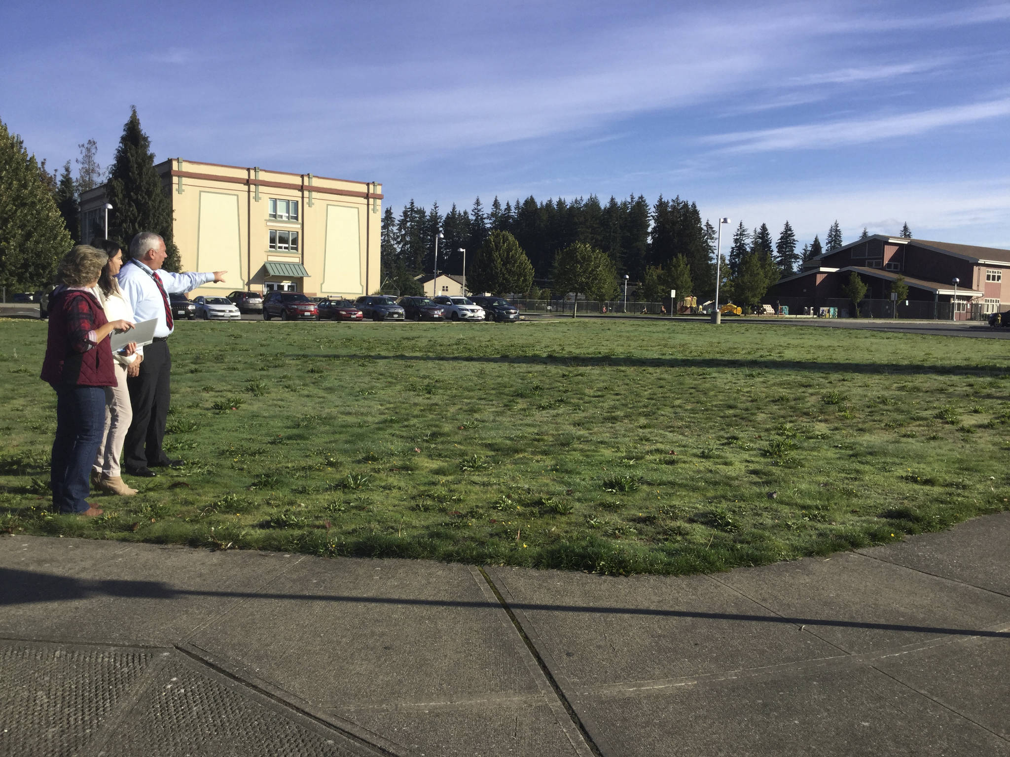 From left, Beth Countryman, coordinator, Sarah Lopez, city community revitalization project manager Sarah Lopez and Brian Lewis, executive director of Operations with Arlington Public Schools view a patch of grassy land at N. French Avenue and E 3rd Street that will be transformed into a community garden.