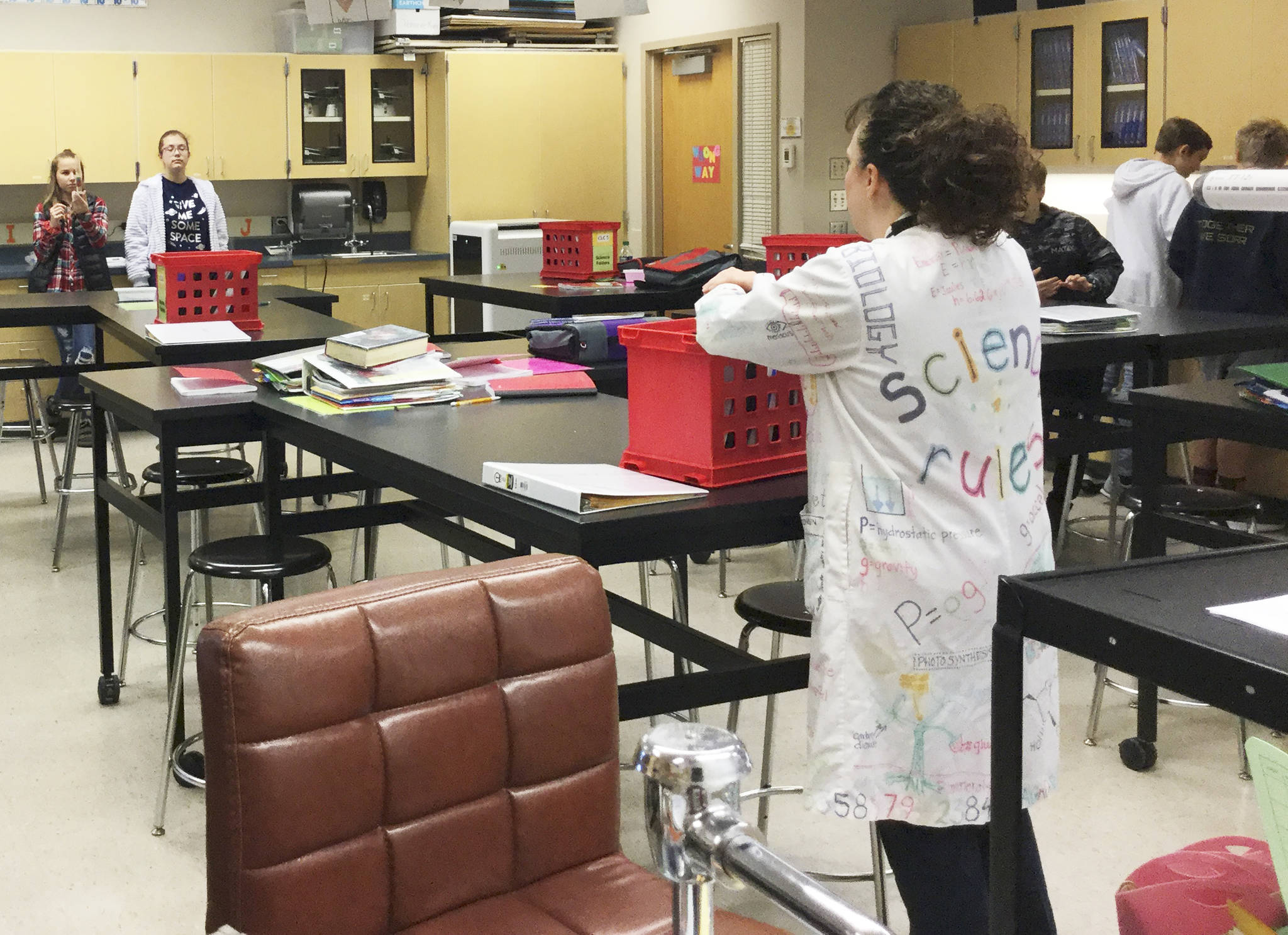 Lab partners in Earth Sciences teacher Verlaine Meyers class at Haller Middle School hold up their beaker of liquid to share as part of a density measurement exercise.