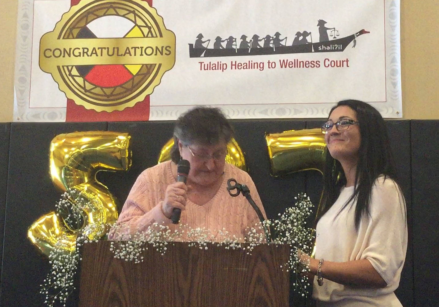 Summerlee Blankenship holds her head high after becoming the first woman to graduate from the Tulalip Tribes’ Healing to Wellness Court. Grandmother Donna Paul was one of several family members and friends to congratulate Blankenship on 537 days of sobriety completing the Wellness Court. Inset left, she received a hand-carved mask titled “A Sacred Journey.”