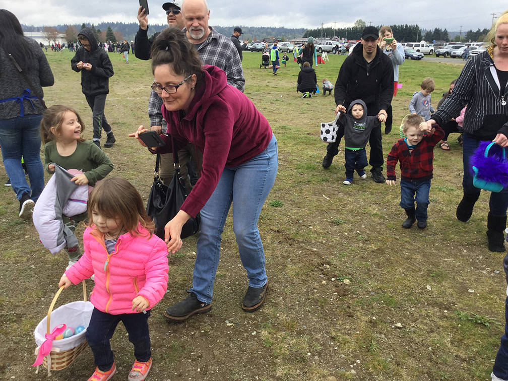 Arlington 2-year-old Eleanor Ballentine is off to a fast start filling her basket at the annual Arlington Easter Egg Hunt Saturday, with backup support from mom, Nicole.
