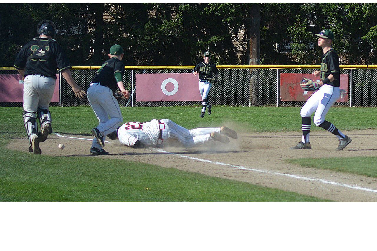 Chase Brammer (23) of Marysville-Pilchuck dives safely into third base after being caught in a rundown against Marysville Getchell Wednesday. M-P won the game 10-0 after losing to the Chargers the day before 6-5. For more, see Page 11. (Steve Powell/Staff Photo)
