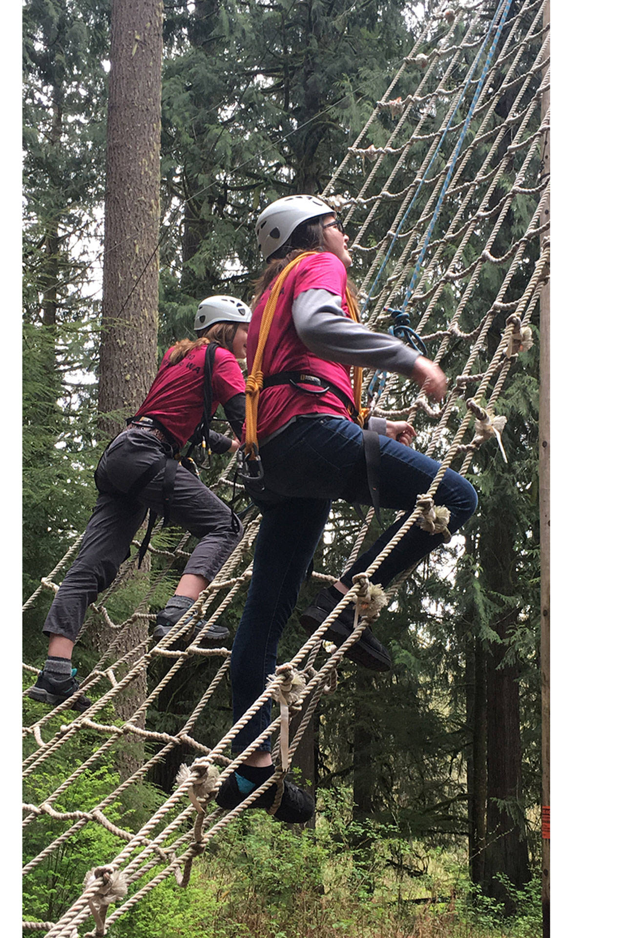 Jackie Shea and Natalie Hawkins climb up a rope ladder at Boy Scout camp. (Courtesy Photo)