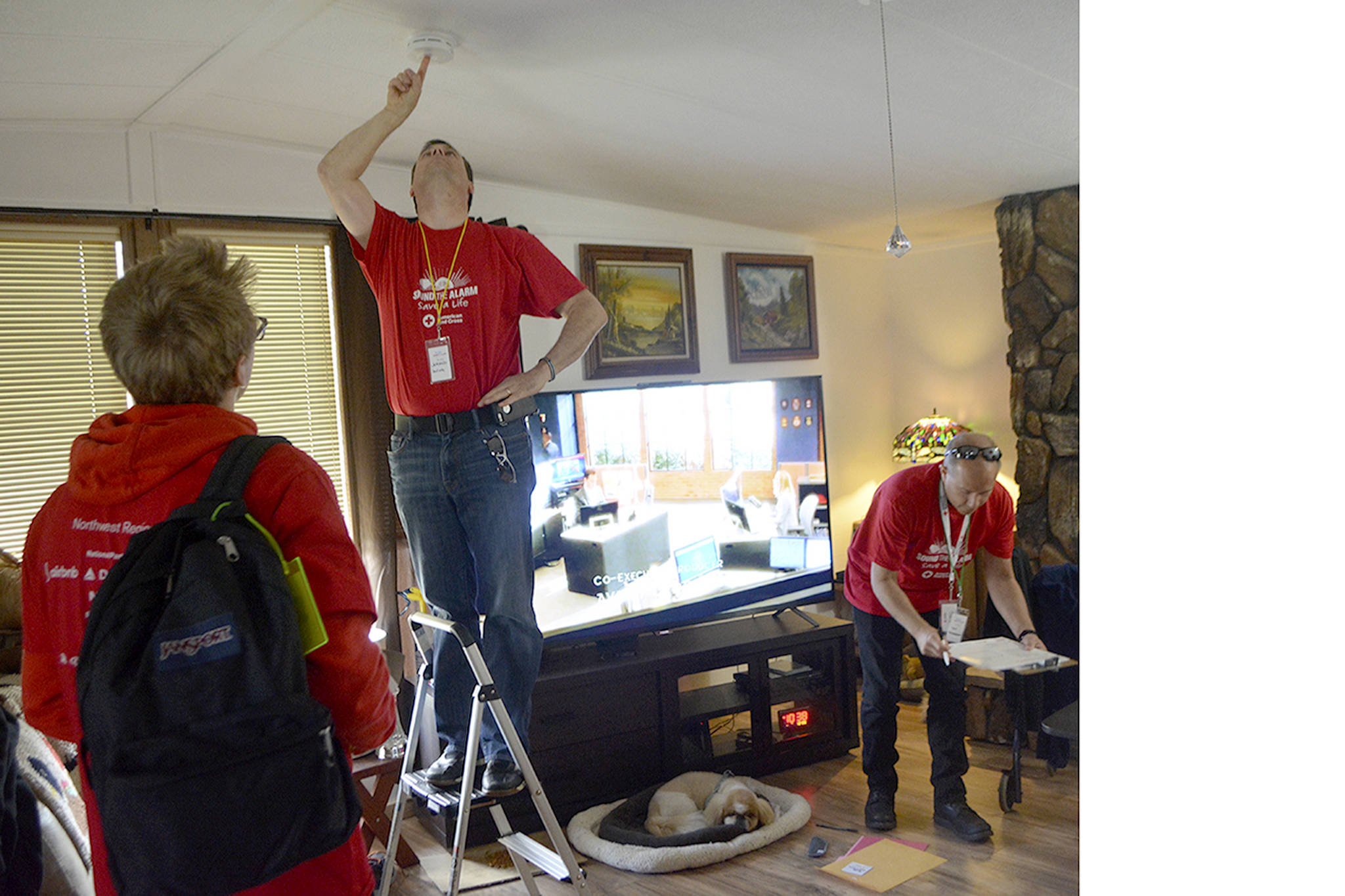 Jeraud Irvin of Snohomish puts up a smoke alarm in a home in the Glenwood neighborhood of Marysville Saturday as part of the free Sound the Alarm program with the American Red Cross. (Steve Powell/Staff Photo)