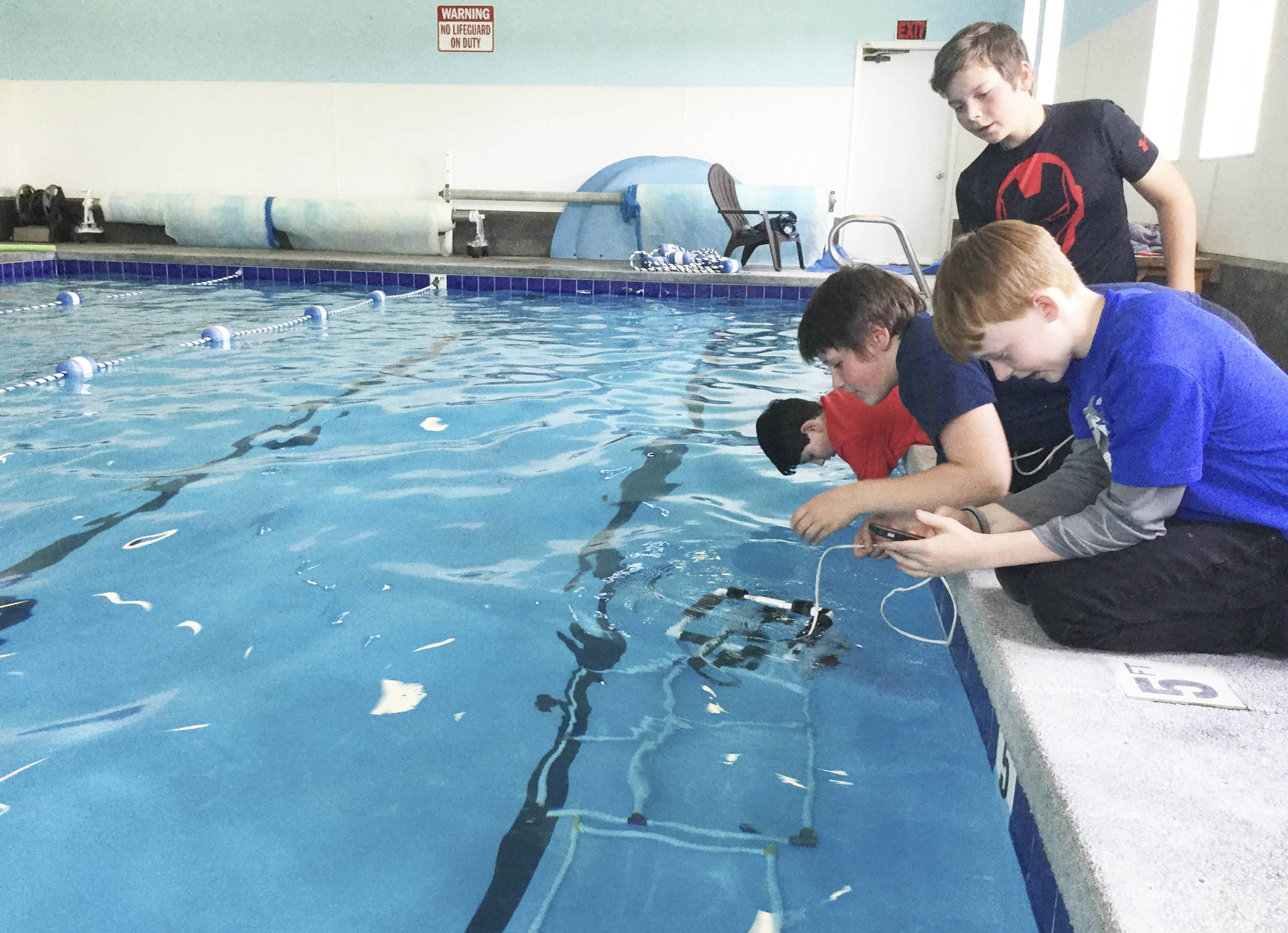 Arlingtons Haller Middle School sixth-graders test their remotely-operated vehicle (ROV) at the Stillaguamish Athletic Center in Arlington in advance of an underwater robotics competition Saturday in Federal Way. Their team, Shoot The Rapids, will simulate repairing cracks in a dam, among other challenges. From front, Gavin Dill, Cameron Bates, team captain Josiah Christoffersen and Simon Daley. Not pictured, Jacob Madriaga.