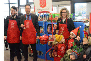 Lt. Ruari Ward, left, with Mayor Jon Nehring and Wards wife, Sarah, and their children, shown here at the Salvation Army bell ringing red kettle fund-raising drive before Christmas. (File Photo)