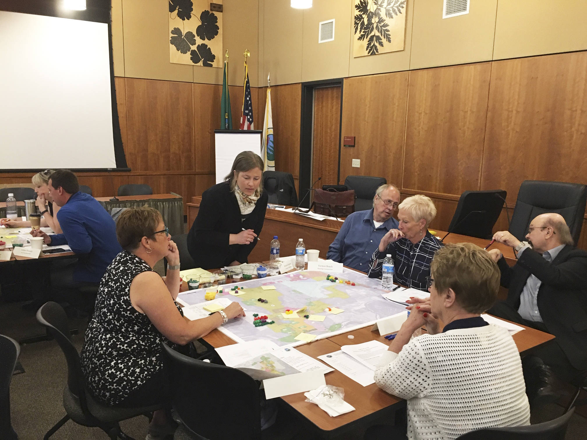 Arlington City Councilman Mike Hopson (right) confers with planning commissioner Vernon Beach, while councilwomen Debra Nelson, Marilyn Oertle and Jan Schuette ponder their next housing move.