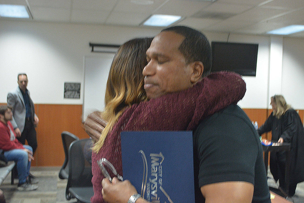 Cecilio Smith gets a hug from liaison Cathy Wheatcroft after the graduation. (Steve Powell/Staff Photo)