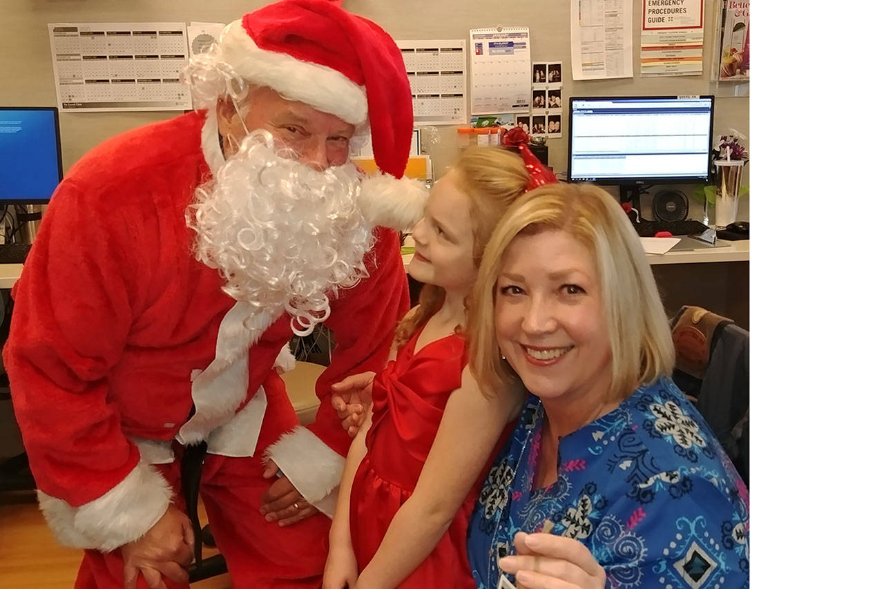 Reese Estes of Marysville, accompanined by Santa, gave out ornaments to nurses like Andi Moore. (Courtesy Photo)