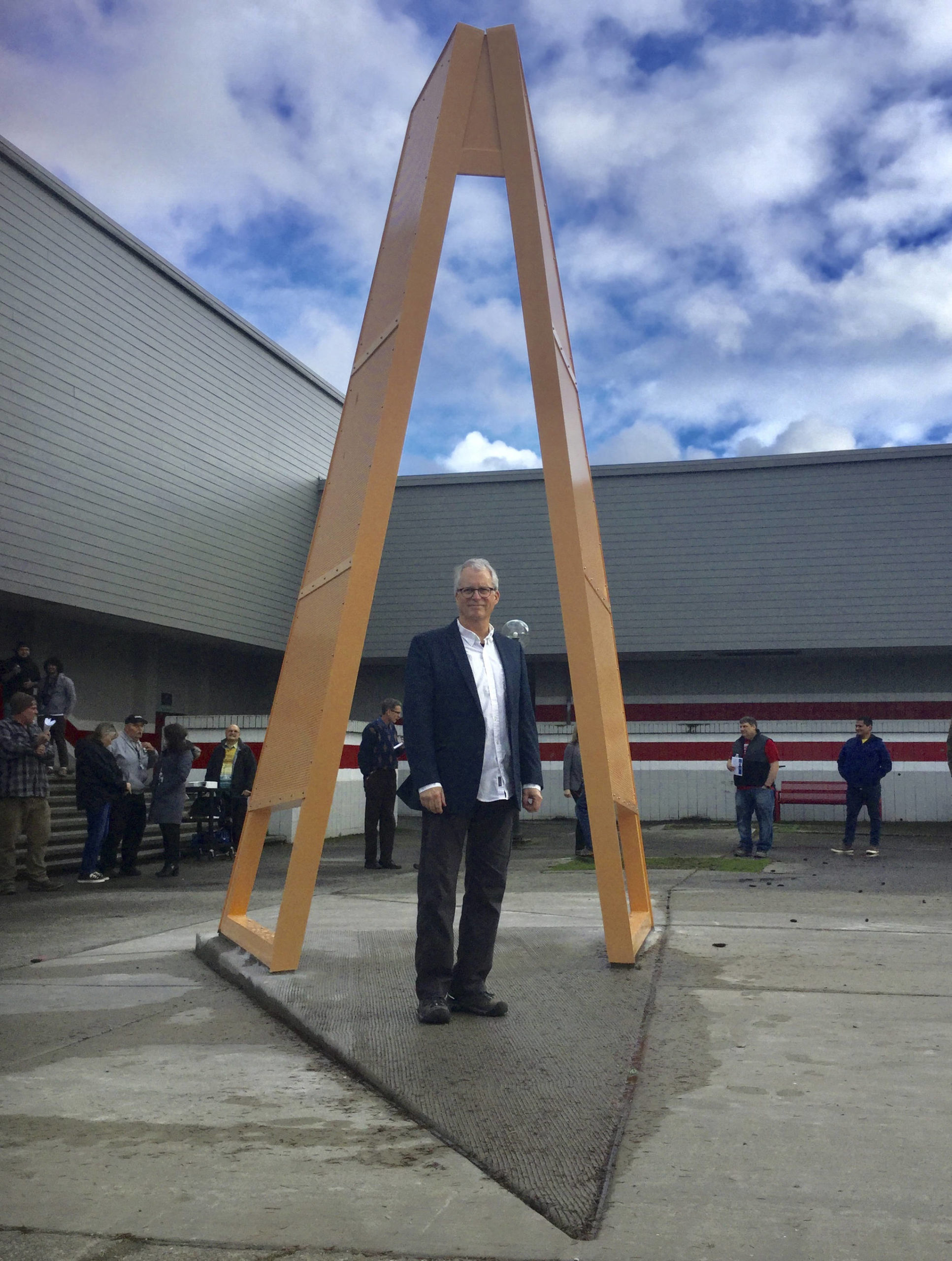 Artist Roger Feldman, professor emeritus at Seattle Pacific University, passes through his newest sculpture, HopeGate unveiled Friday at a ceremony outside Marysville-Pilchuck High School. The interactive sculpture combines Salish Sea Native American elements with a design that invites teens to pass through heading due west and lean into the future.