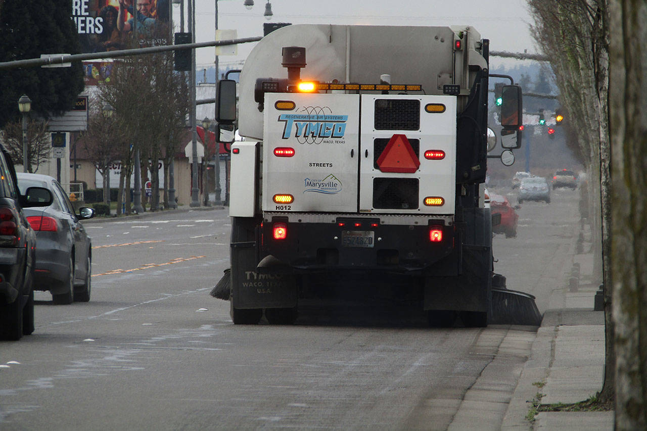 A street sweeper cruises down the road.